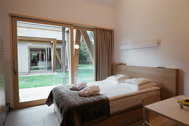 Bungalovy PREKMURSKA VAS AJDA - obývací místnost v přízemí (manželská postel + možnost přistýlky), jednolůžková postel v podkroví - typ Bungalov 3(+1) Superior